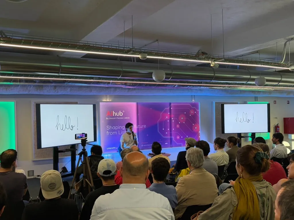 A full room of attendees watching a talk at an Embrace:AI meetup in Lisbon